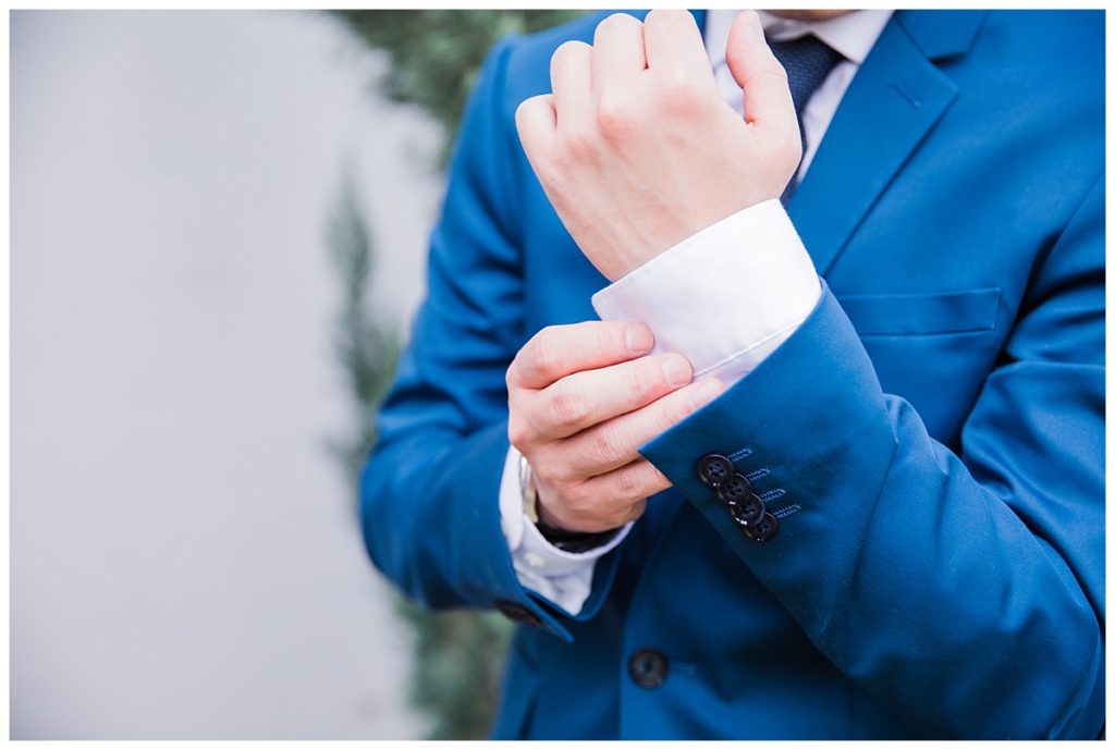Close up of groom in navy suit adjusting sleeves photographed by Dallas wedding photographer Picture Bouquet Studio.