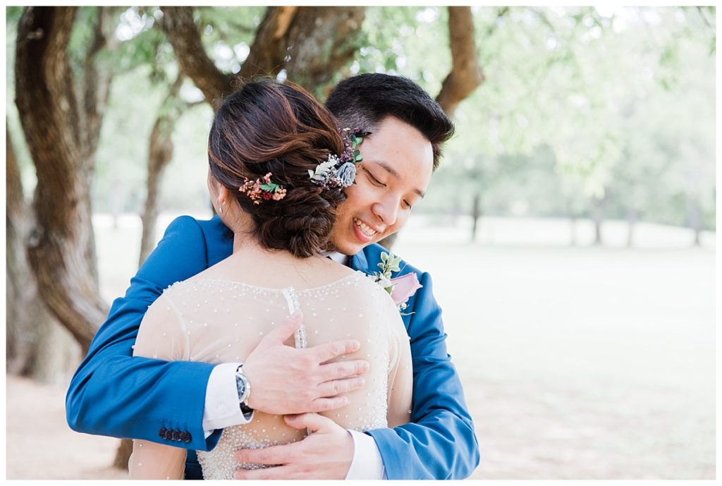 Groom hugs Vietnamese bride for first look at Stonebridge wedding and events venue photographed by Jenny Bui of Picture Bouquet Studio. 