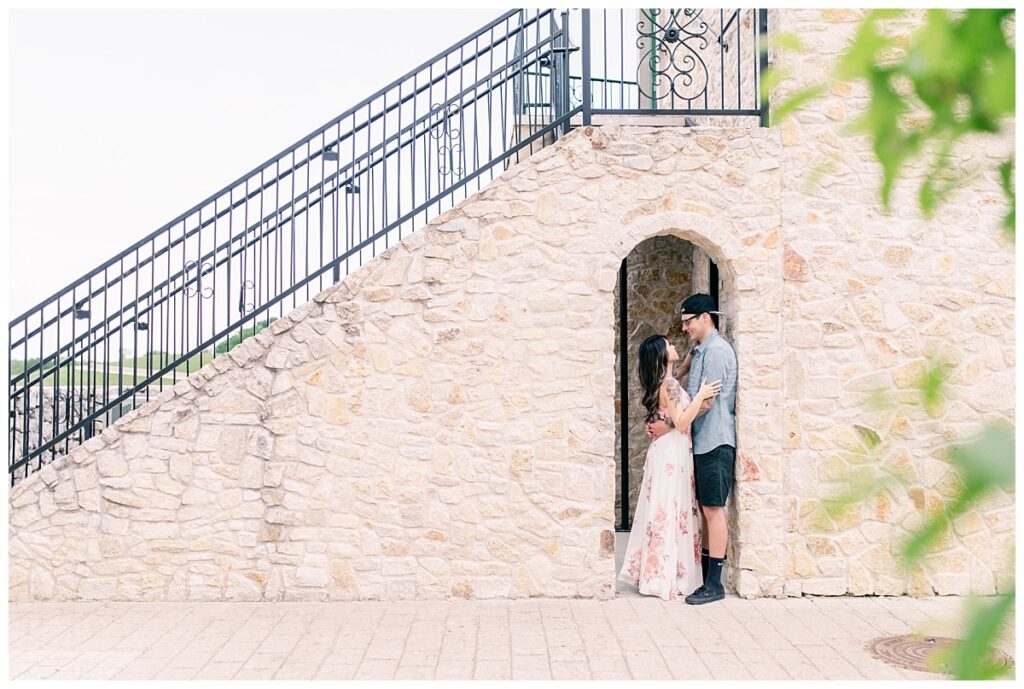 Engaged couple gazes at one another in secret doorway for an Adriatica Village engagement session photographed by Dallas wedding photographer Jenny Bui of Picture Bouquet Studio. 