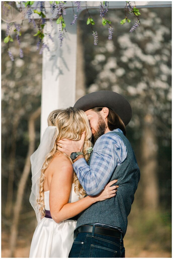 Texas styled bride and groom's first kiss for outdoor Texas styled wedding at Fort Worth Country Memorial Wedding Venue photographed by Dallas wedding photographer Jenny Bui of Picture Bouquet Studio. 