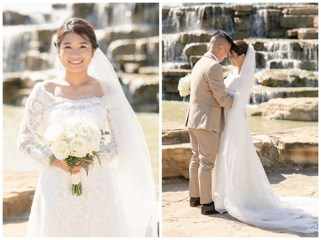 Groom in tan suit presses forehead together with bride in off shoulder long sleeve lace wedding dress and long veil with white bouquet on right and bride poses with white rose bouquet on left image in front of rock waterfall during bridal party portraits at Flower Mound River Walk photographed by Dallas wedding photographer, Jenny Bui of Picture Bouquet Studio. 