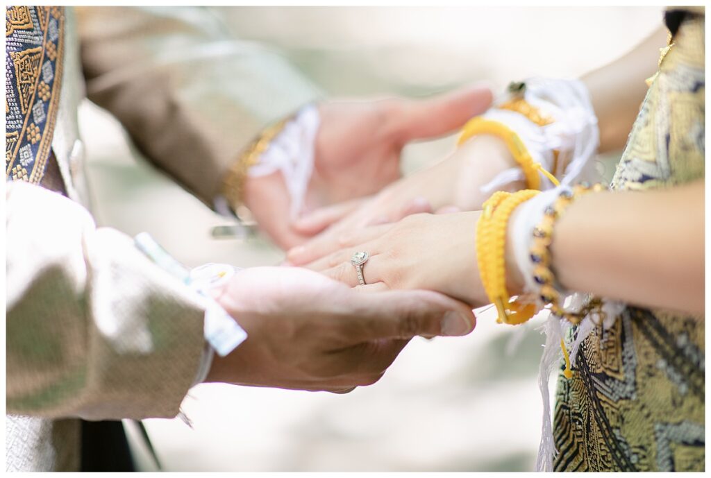 Close up of groom holding bride's hands for Laotian wedding portrait session at North Richland HIll's park for Jenny Bui of Picture Bouquet Studio, a wedding photography studio serving the Dallas and surrounding areas. 