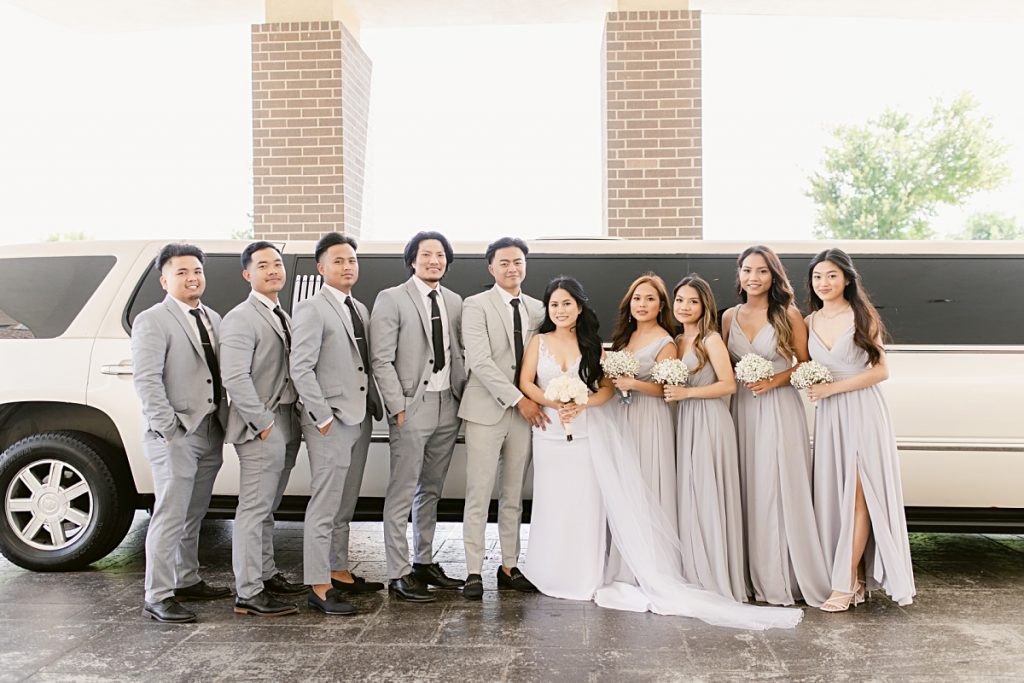 Asian bridal party poses in front of white limousine photographed by Dallas Vietnamese wedding photographer Jenny Bui of Picture Bouquet Studio. 
