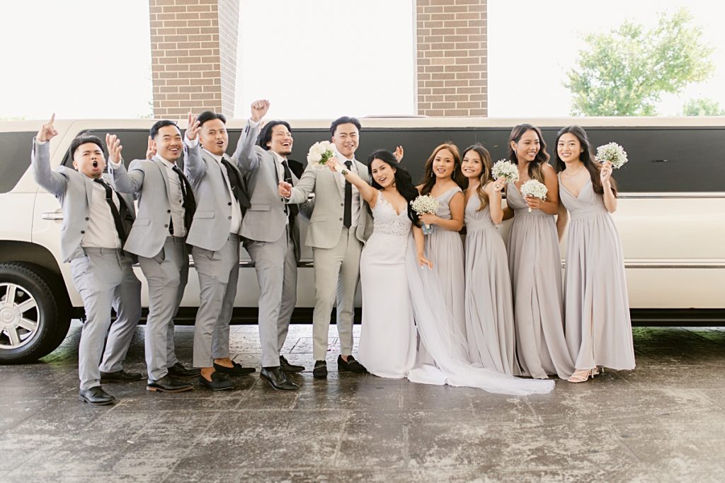 Bridal party cheering in front of white limousine photographed by Dallas Vietnamese wedding photographer Jenny Bui of Picture Bouquet Studio. 