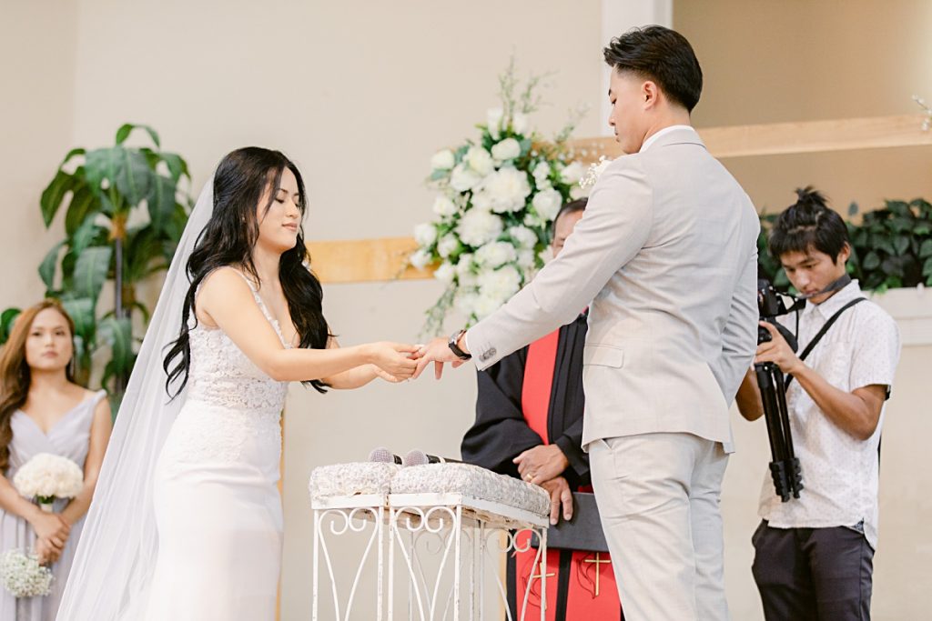 Bride placing ring on groom's finger at Chin Revival Church photographed by Dallas Wedding photographer Picture Bouquet Studio. 