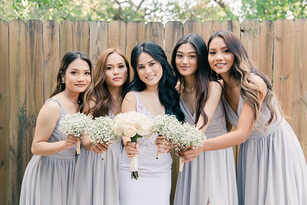 Bridesmaids with baby breaths bouquet poses with bride for wedding at Chin Revival Church photographed by Picture Bouquet Studio. 