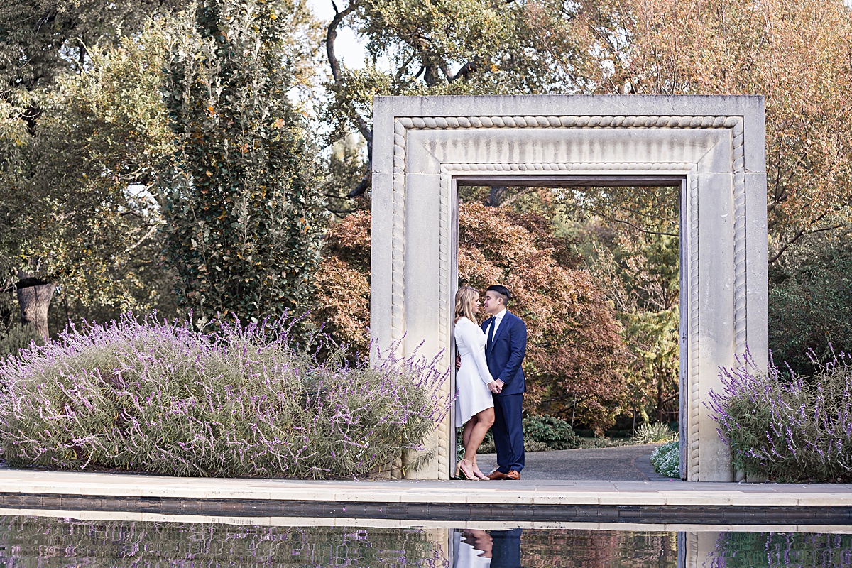 Engaged couple gazing at one another under photo frame at the Dallas Arboretum photographed by Dallas wedding photographer Jenny Bui of Picture Bouquet Studio.