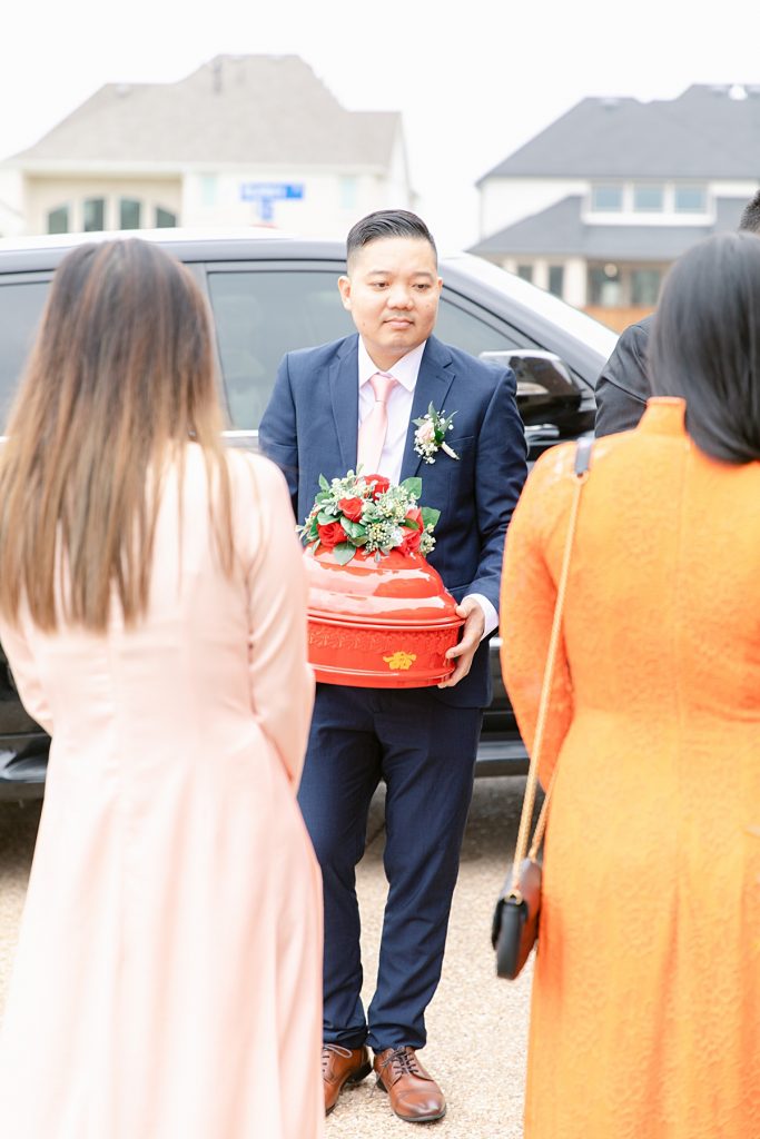 Groomsmen holding red tray during Vietnamese tea ceremony for photographed by Dallas Vietnamese wedding photographer Jenny Bui of Picture Bouquet Studio. 