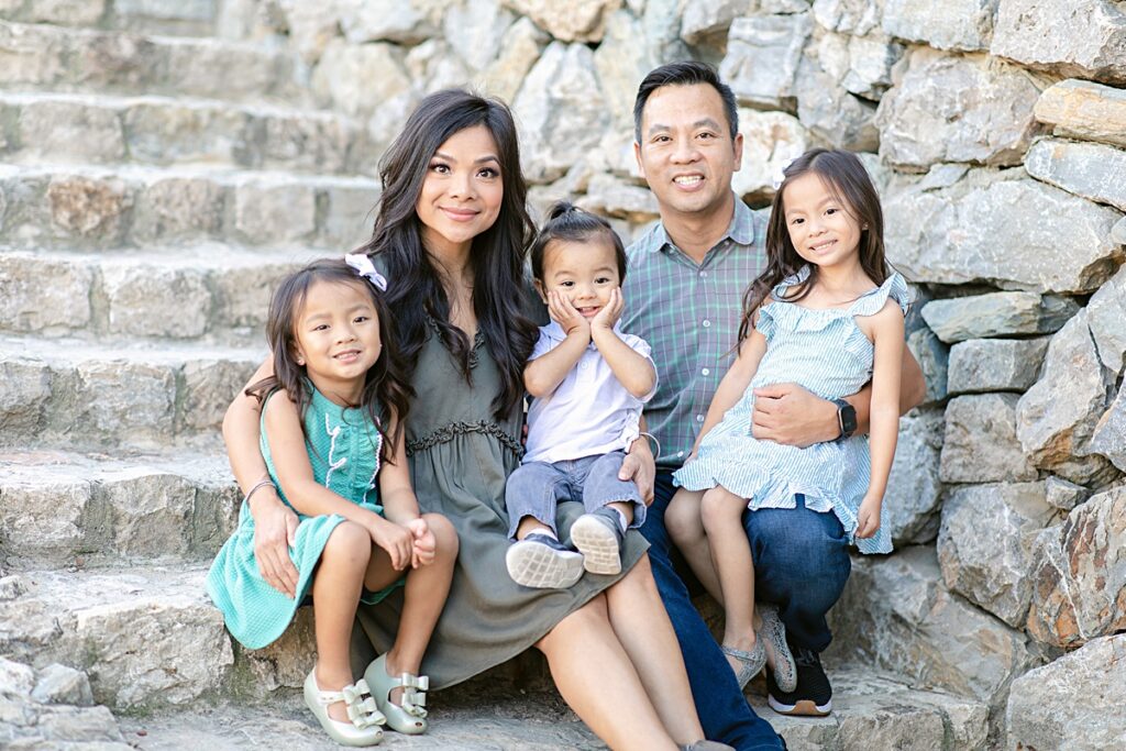 Family of five poses on steps at Adriatica Village for family session photographed by Mckinney family photographer Picture Bouquet Studio. 