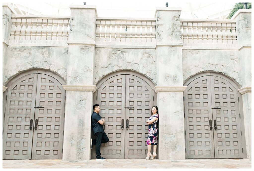 Guy gazes at fiancee in front of castle door at Gaylord Texan Resort for engagement session photographed by Dallas Wedding photographer Jenny Bui of Picture Bouquet Studio. 