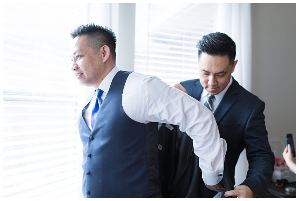 Groom in royal blue tie getting ready on wedding day for Dallas Vietnamese wedding photographed by Jenny Bui of Picture Bouquet Studio. 