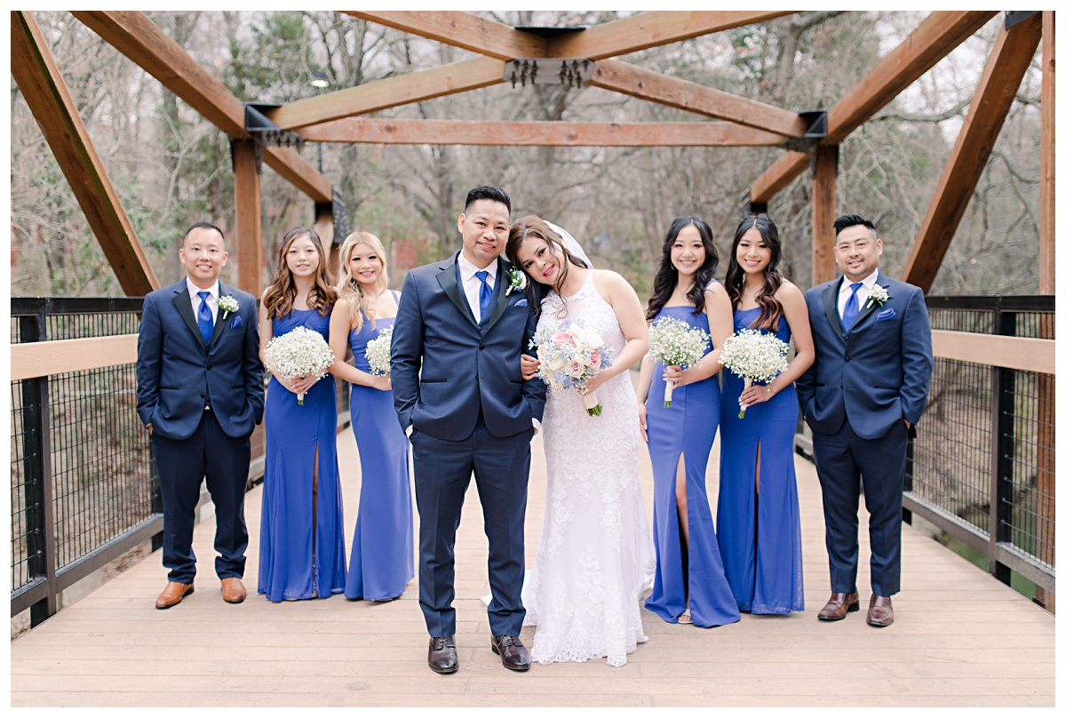 Royal blue bridal party poses on bridge at Prairie Creek Park in Richardson, TX for bridal party photos for Dallas Vietnamese wedding photographed by Jenny Bui of Picture Bouquet Studio. 