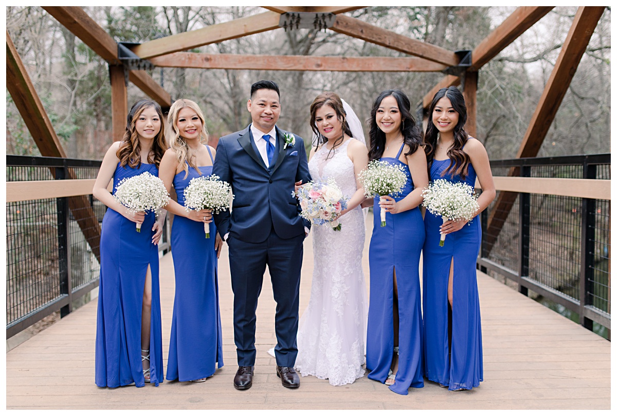 Royal blue bridal party poses on bridge at Prairie Creek Park in Richardson, TX for bridal party photos for Dallas Vietnamese wedding photographed by Jenny Bui of Picture Bouquet Studio. 