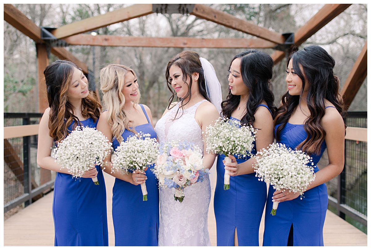 Bridesmaid in royal blue poses with bride at Prairie Creek Park in Richardson, TX for bridal party photos for Dallas Vietnamese wedding photographed by Jenny Bui of Picture Bouquet Studio. 