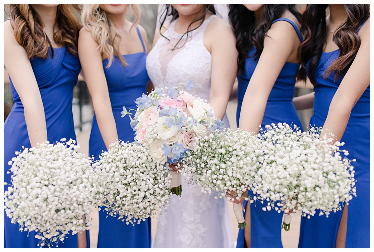 Close up of bridal bouquet and bridesmaids in royal blue bouquets at Prairie Creek Park in Richardson, TX for bridal party photos for Dallas Vietnamese wedding photographed by Jenny Bui of Picture Bouquet Studio. 
