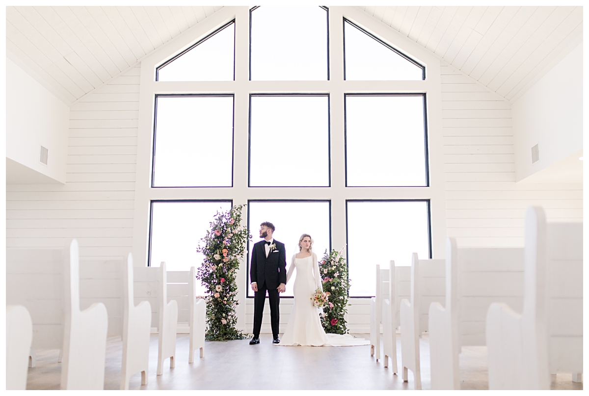 Bride and groom holding hand in all white chapel at The Gardenia Venue for styled shoot photographed by Jenny Bui of Picture Bouquet Studio.