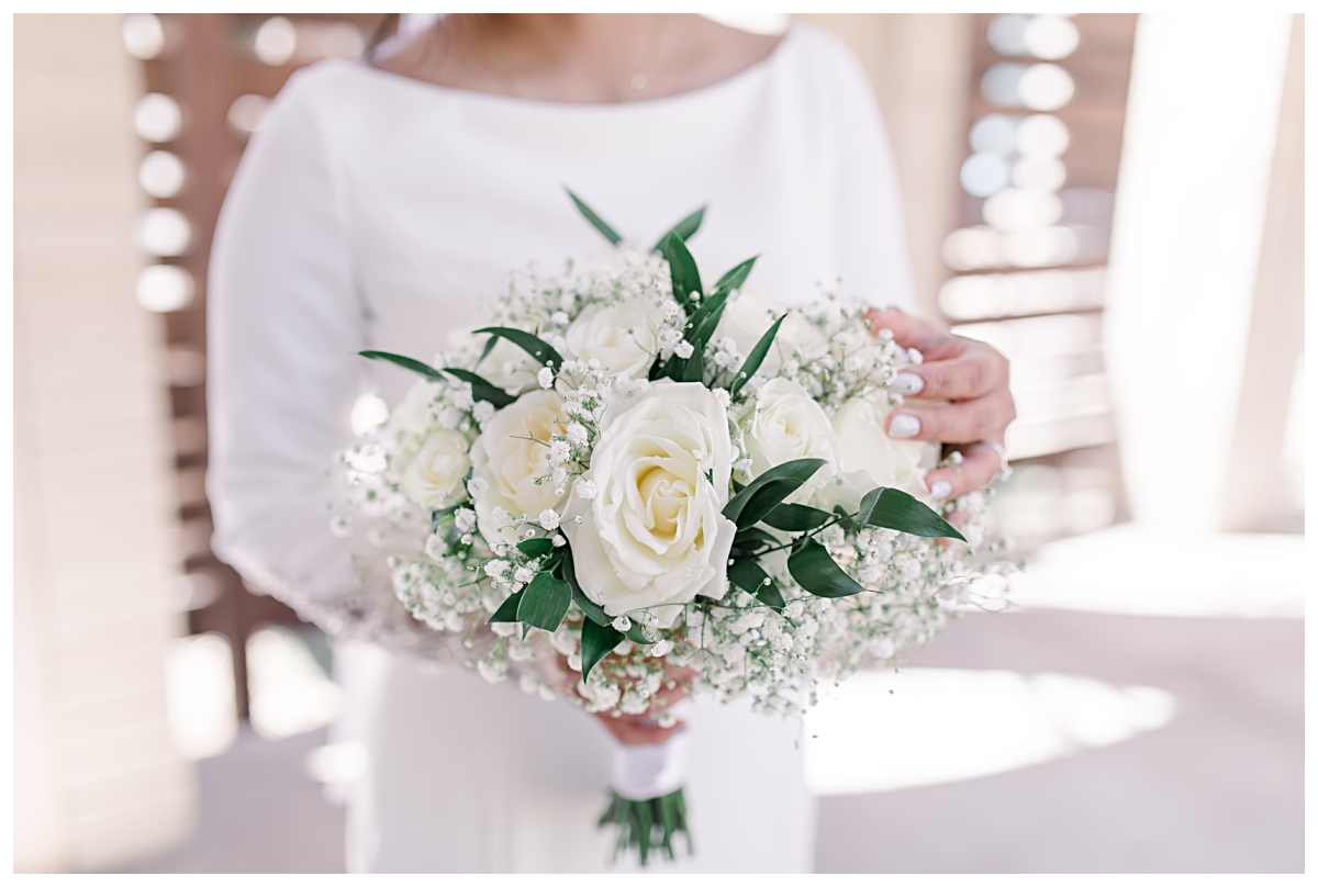 Close up of bride's white roses and baby's breath bouquet from a Dallas Asian wedding photographed by Jenny Bui of Picture Bouquet Studio. 