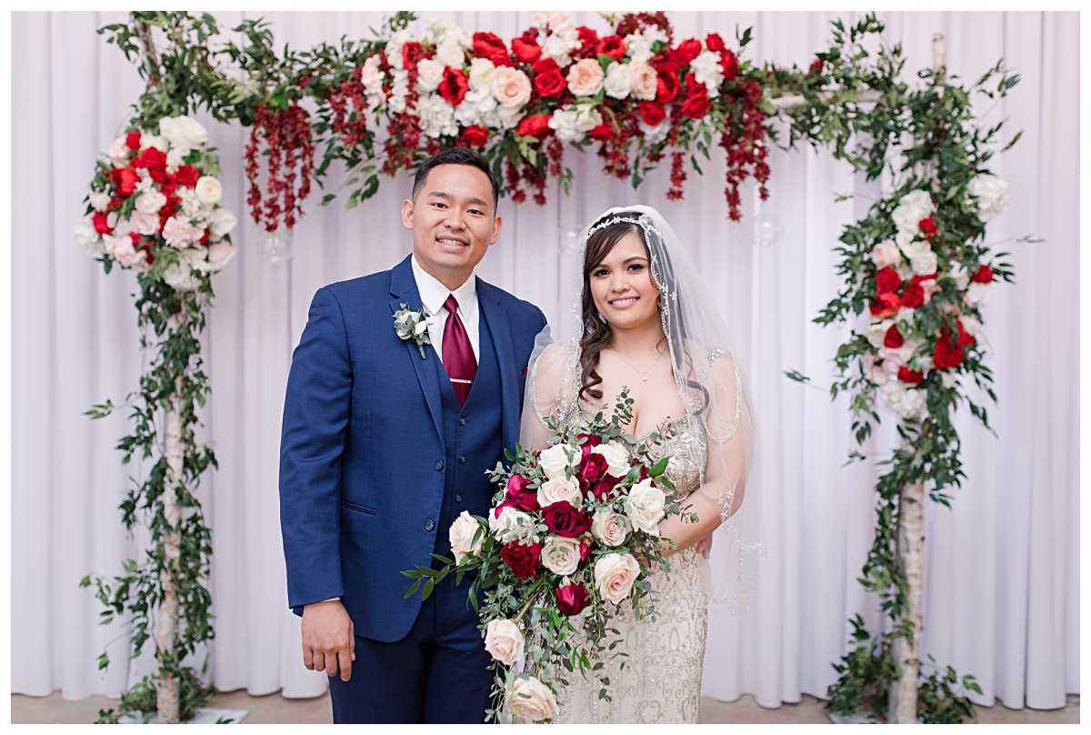 Bride in vintage beaded wedding dress and groom in navy suit posing for wedding photo at Zander House photographed by Dallas wedding photographer Jenny Bui of Picture Bouquet Studio.  