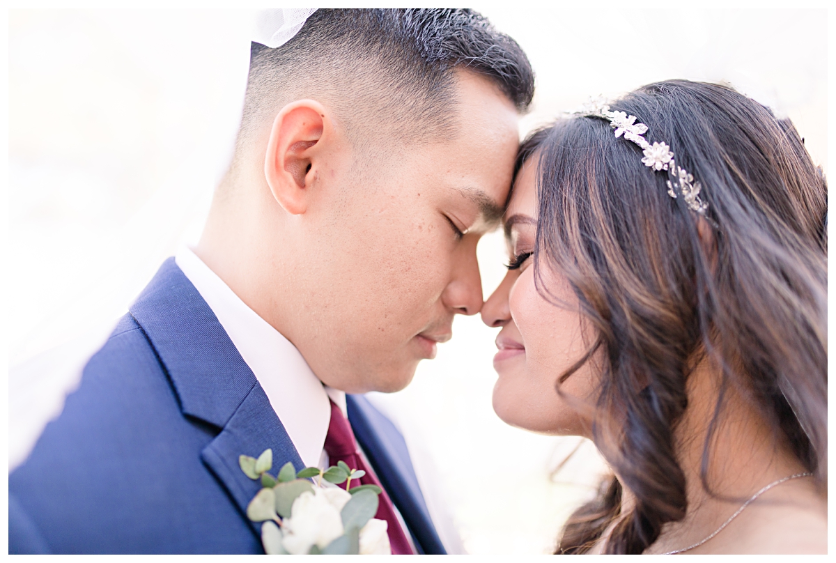 Bride and groom shares private moment underneath veil during Dallas Vietnamese wedding at Zander House photographed by Dallas wedding photographer Jenny Bui of Picture Bouquet Studio. 