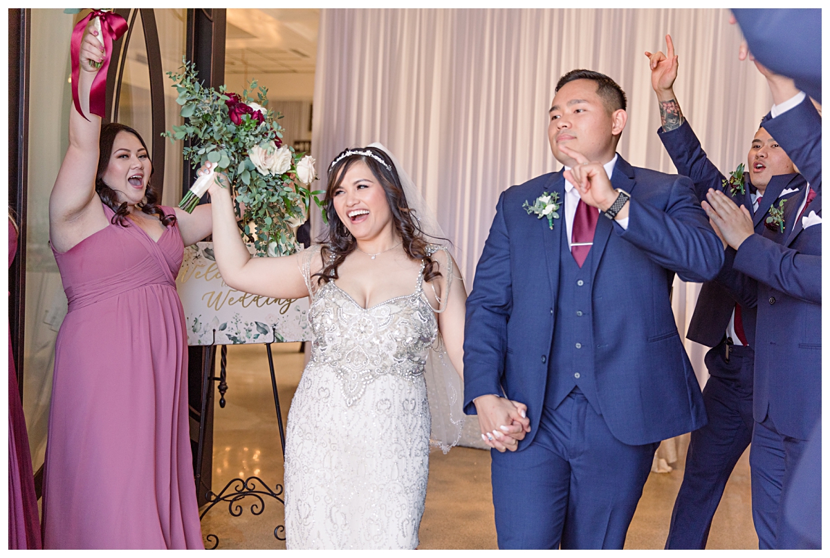 Bride in vintage beaded wedding dress and groom in navy suit and burgundy tie dances during exit during Dallas Vietnamese wedding at Zander House photographed by Dallas wedding photographer Jenny Bui of Picture Bouquet Studio. 