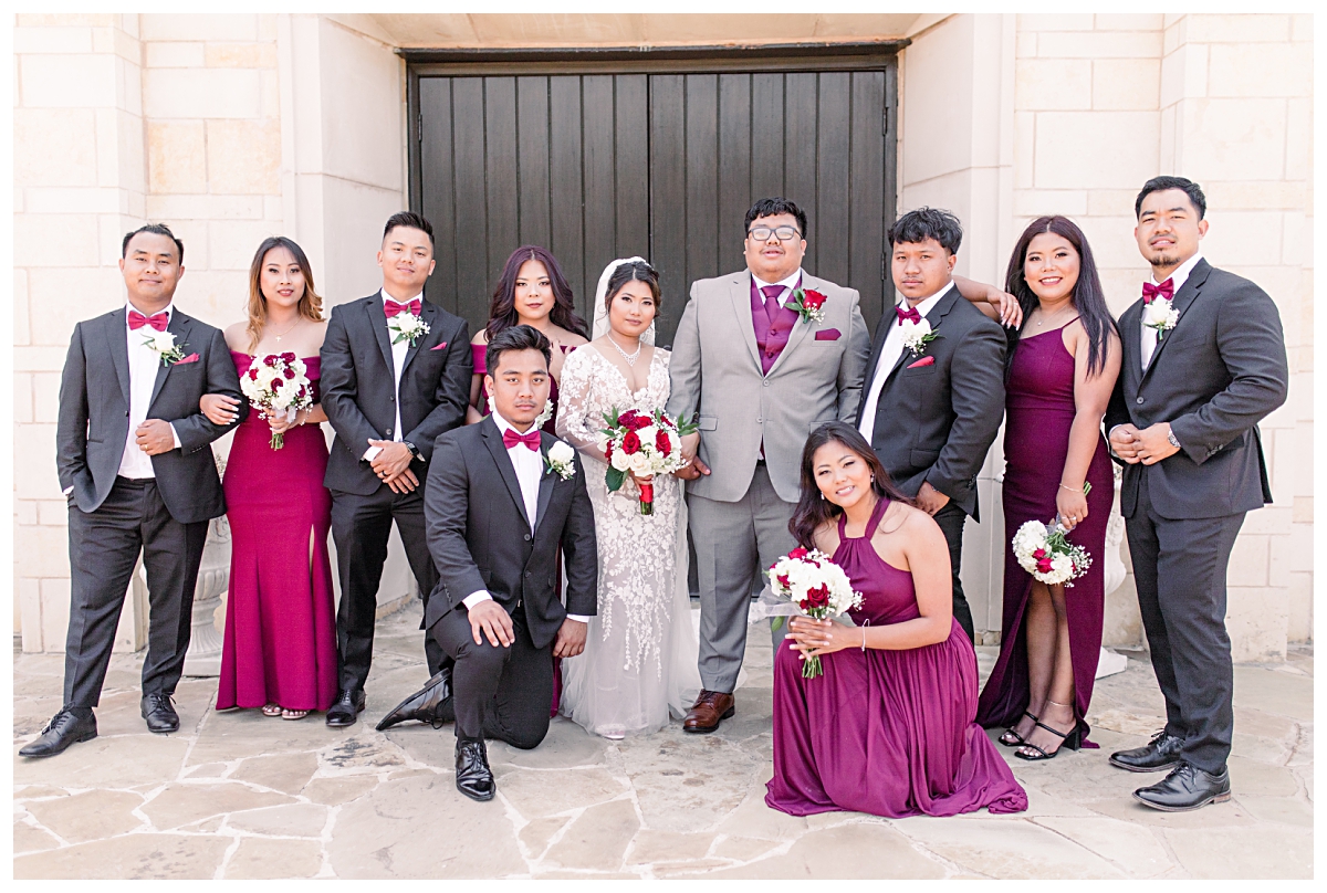 Bridal party in burgundy and cream poses in front of Riverwalk chapel for wedding portraits at Flower Mound Riverwalk photographed by Dallas wedding photographer Jenny Bui of Picture Bouquet Studio. 