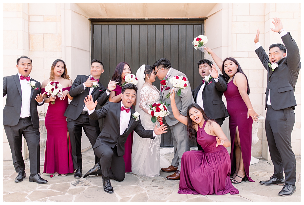 Bridal party cheers as bride and groom leans in for wedding portraits at Flower Mound Riverwalk photographed by Dallas wedding photographer Jenny Bui of Picture Bouquet Studio. 