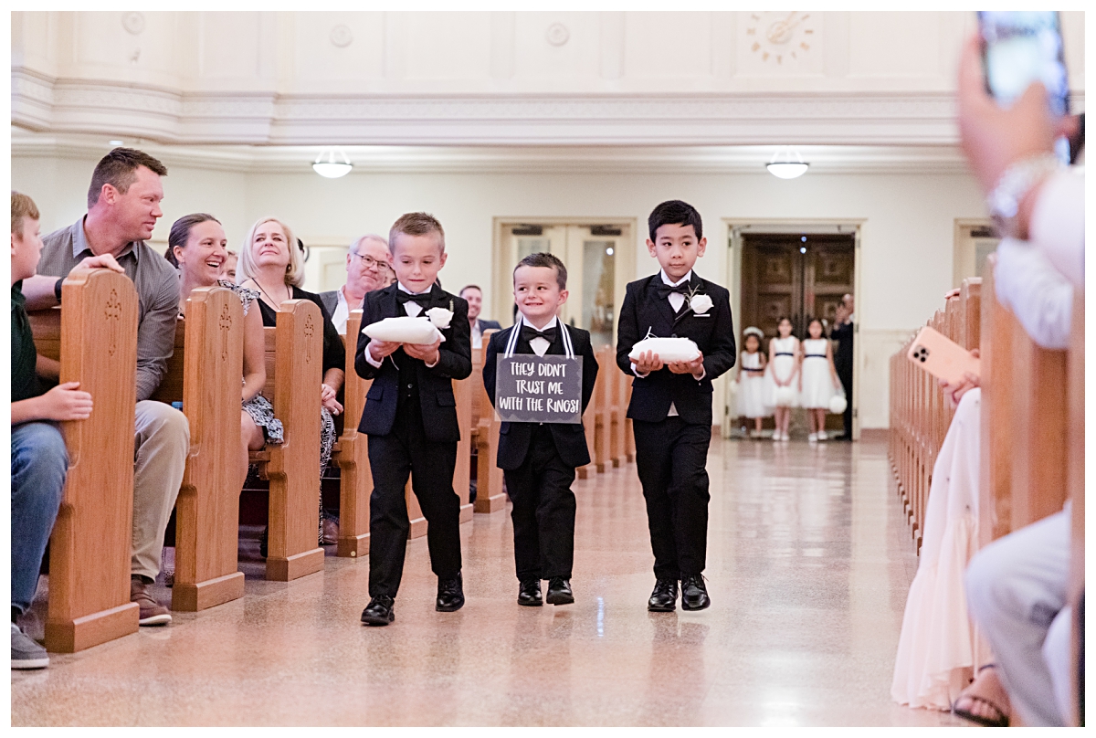 Cutest little ring bearers with signs photographed by Dallas wedding photographer Jenny Bui of Picture Bouquet Studio for Holy Trinity Catholic Church wedding in Dallas, TX.  