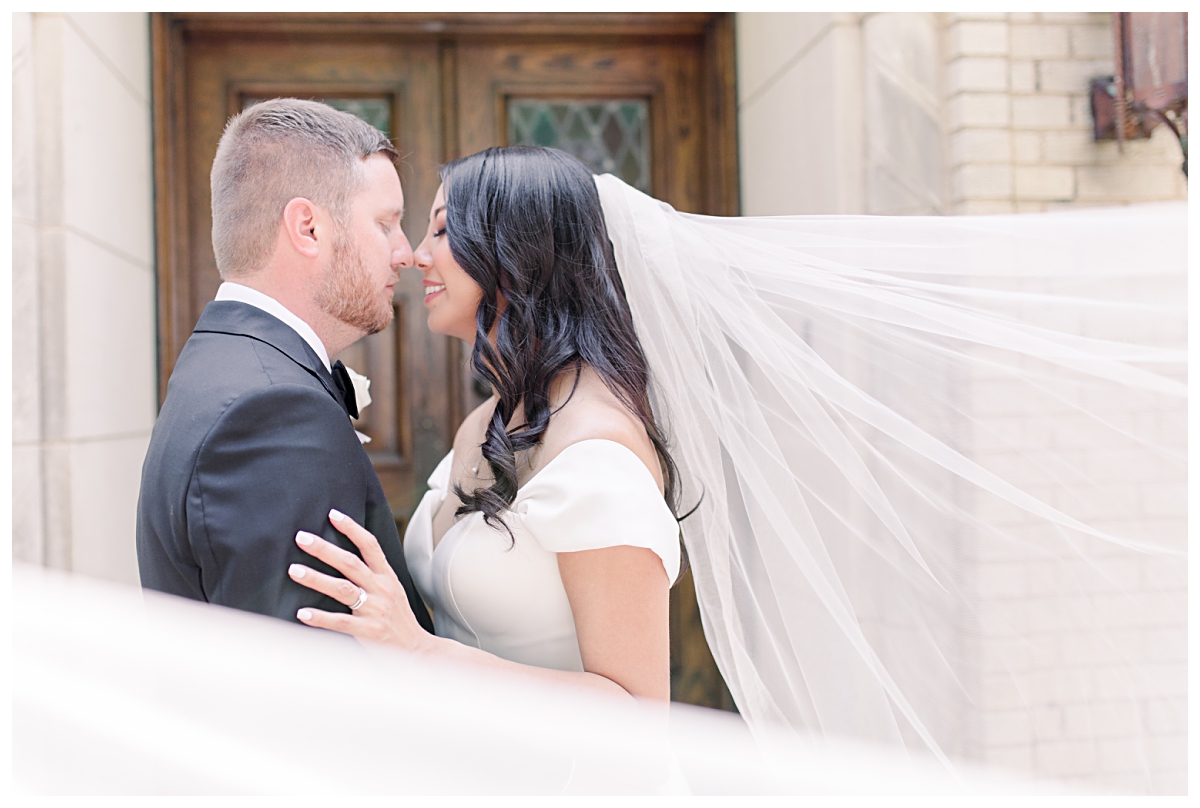 Bride and groom nose to nose for wedding portrait at Holy Trinity Catholic Church in Dallas photographed by Jenny Bui of Picture Bouquet Studio.