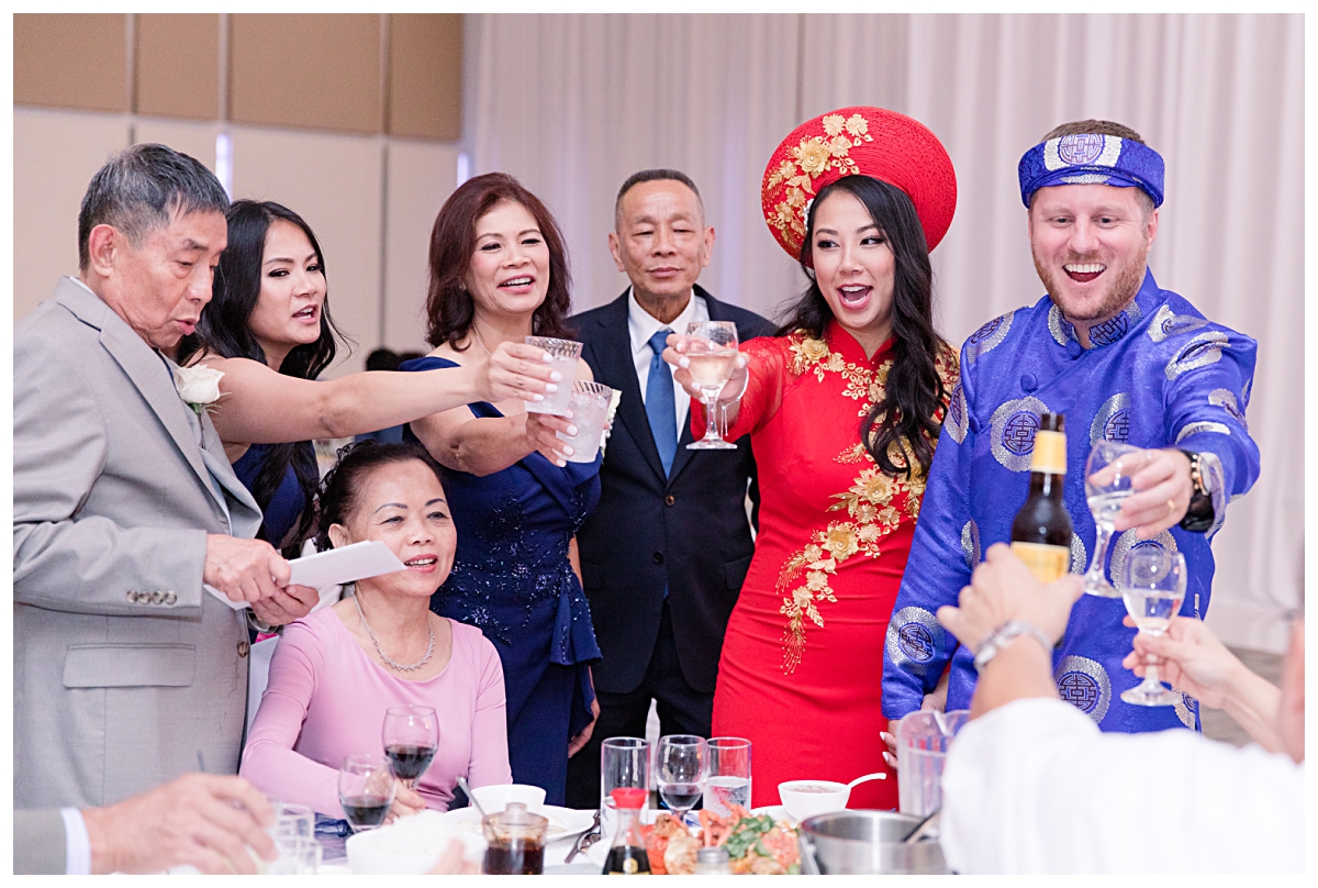 Toasts with guest during table greeting for Dallas Vietnamese wedding photographed by Dallas wedding photographer Jenny Bui of Picture Bouquet Studio for The Pearl  wedding in Dallas, TX.   