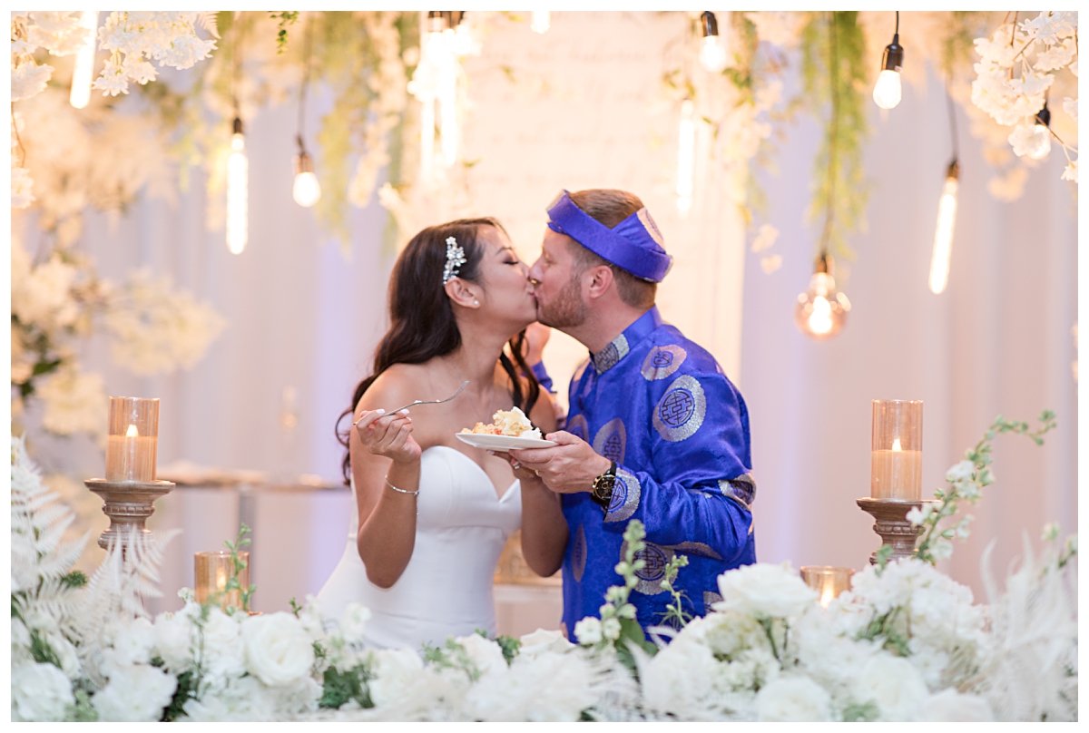 Bride and groom shares kiss after cake cutting photographed by Dallas wedding photographer Jenny Bui of Picture Bouquet Studio for The Pearl  wedding in Dallas, TX.   