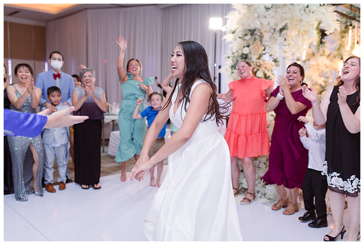 Bride happily dancing during her wedding day reception photographed by Dallas wedding photographer Jenny Bui of Picture Bouquet Studio for The Pearl  wedding in Dallas, TX.   