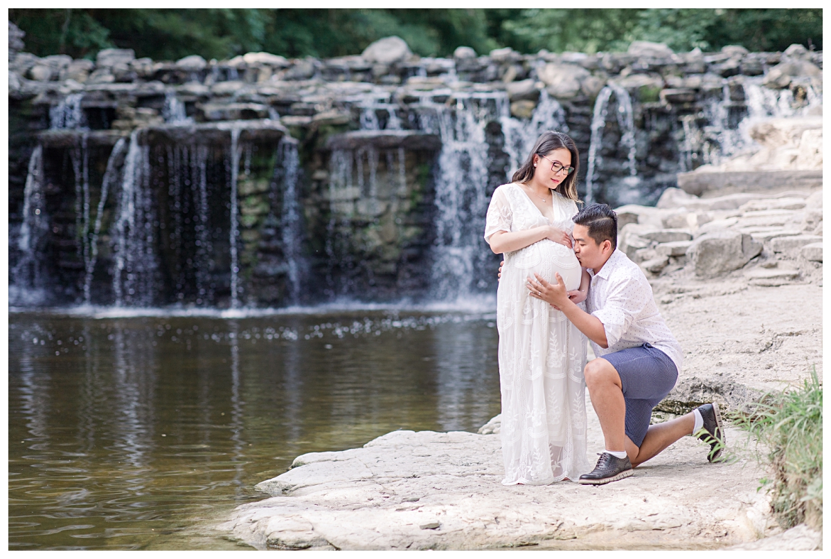 Husband kissing pregnant wife's belly during maternity session at Prairie Creek photographed by Jenny Bui of Picture Bouquet Studio. 