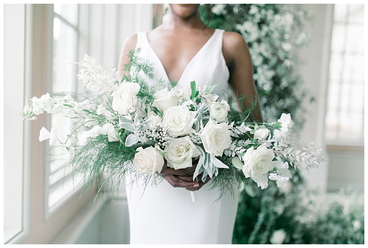 Close of of white rose and greenery bridal bouquet for editorial bridal shoot at The Olana pool room photographed by Dallas wedding photographer Jenny Bui of Picture Bouquet Studio. 