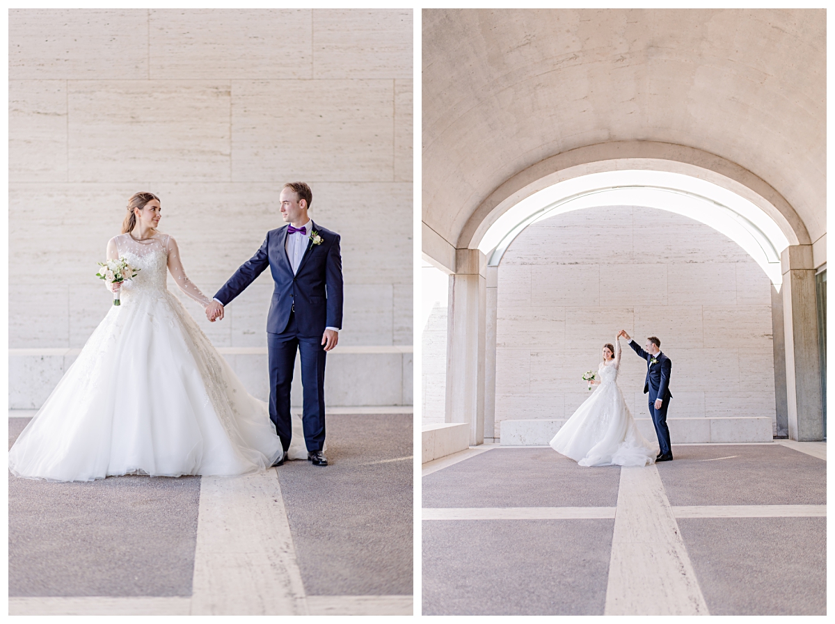 Bride in white wedding dress and groom in navy suit holding hands and twirling underneath archway for Kimbell Art Museum wedding portraits photographed by Dallas wedding photographer Jenny Bui of Picture Bouquet Studio. 